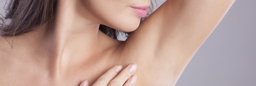 closeup of a woman suffering hyperhidrosis looking at her armpit